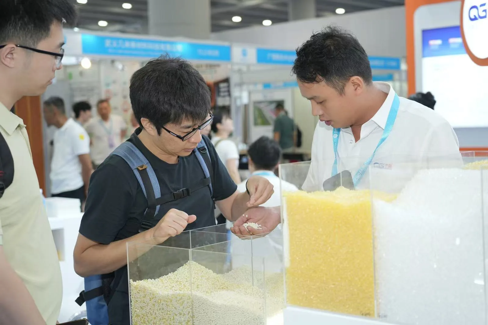 QG Bond team demonstrating hot melt adhesive material sampling at a trade show